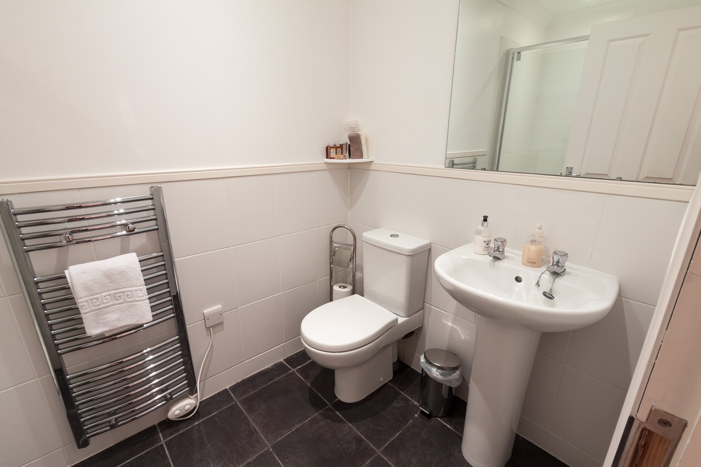 Bathroom with towel radiator, toilet and sink.