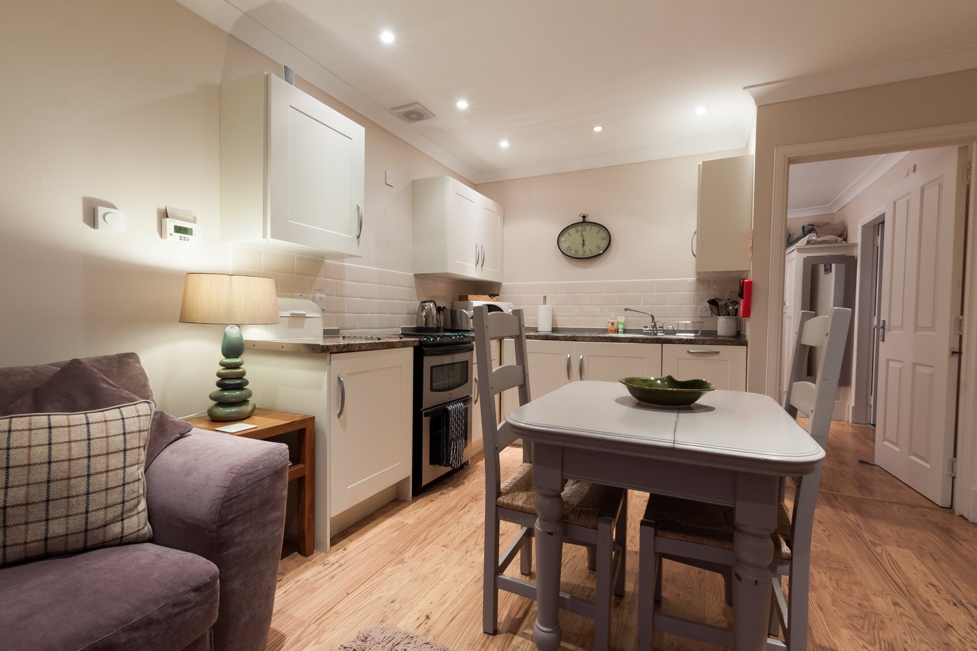 Kitchen with oven and sink and dining table and chairs.