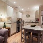 Kitchen with oven and sink and dining table and chairs.