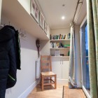 Hallway with chair, bookshelf and window.