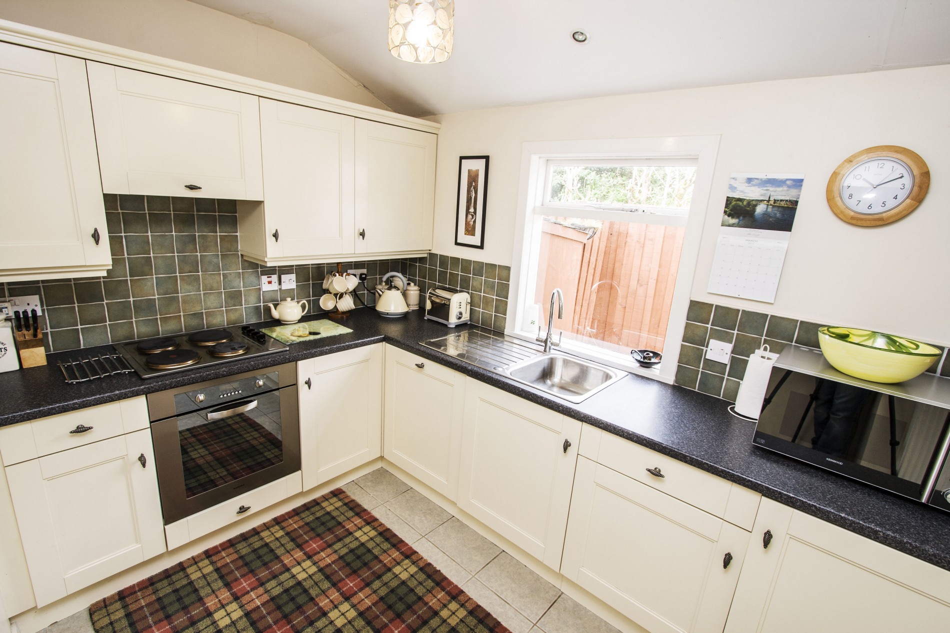 Kitchen with oven, stove, sink and microwave.