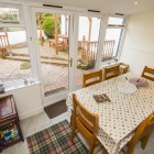 Dining room with large window doors looking out on wooden decking.