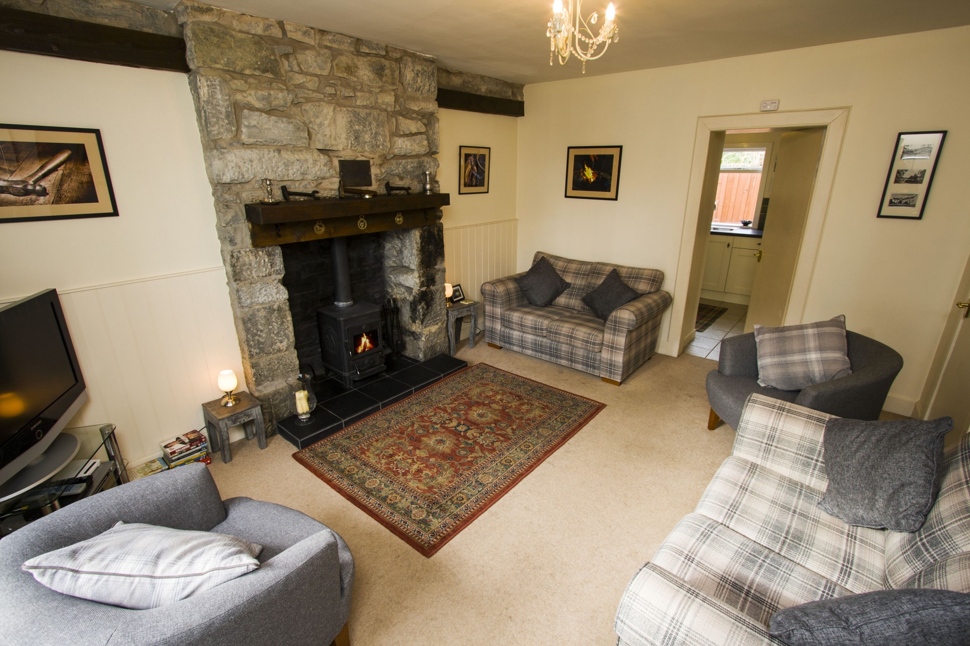 Living room with 2 sofas, 2 arm chairs, TV and fireplace.