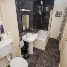 Bathroom with shower/ bath, sink and toilet.