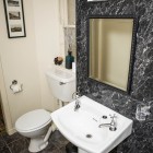 Bathroom with toilet, sink and mirror.