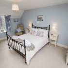 Double bedroom with armchair and window.