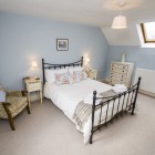 Double bedroom with armchair and chest of drawers.
