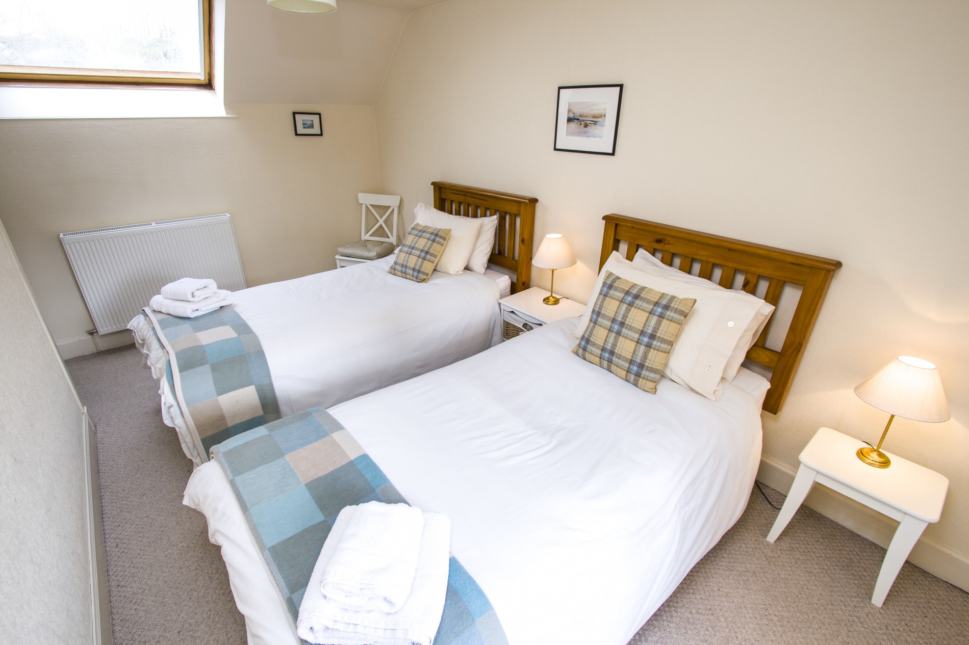 Twin bedroom with chair and bedside tables.
