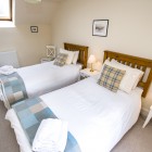 Twin bedroom with chair and bedside tables.