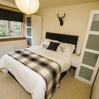 Double bed with two small wardrobes either side and a long window.