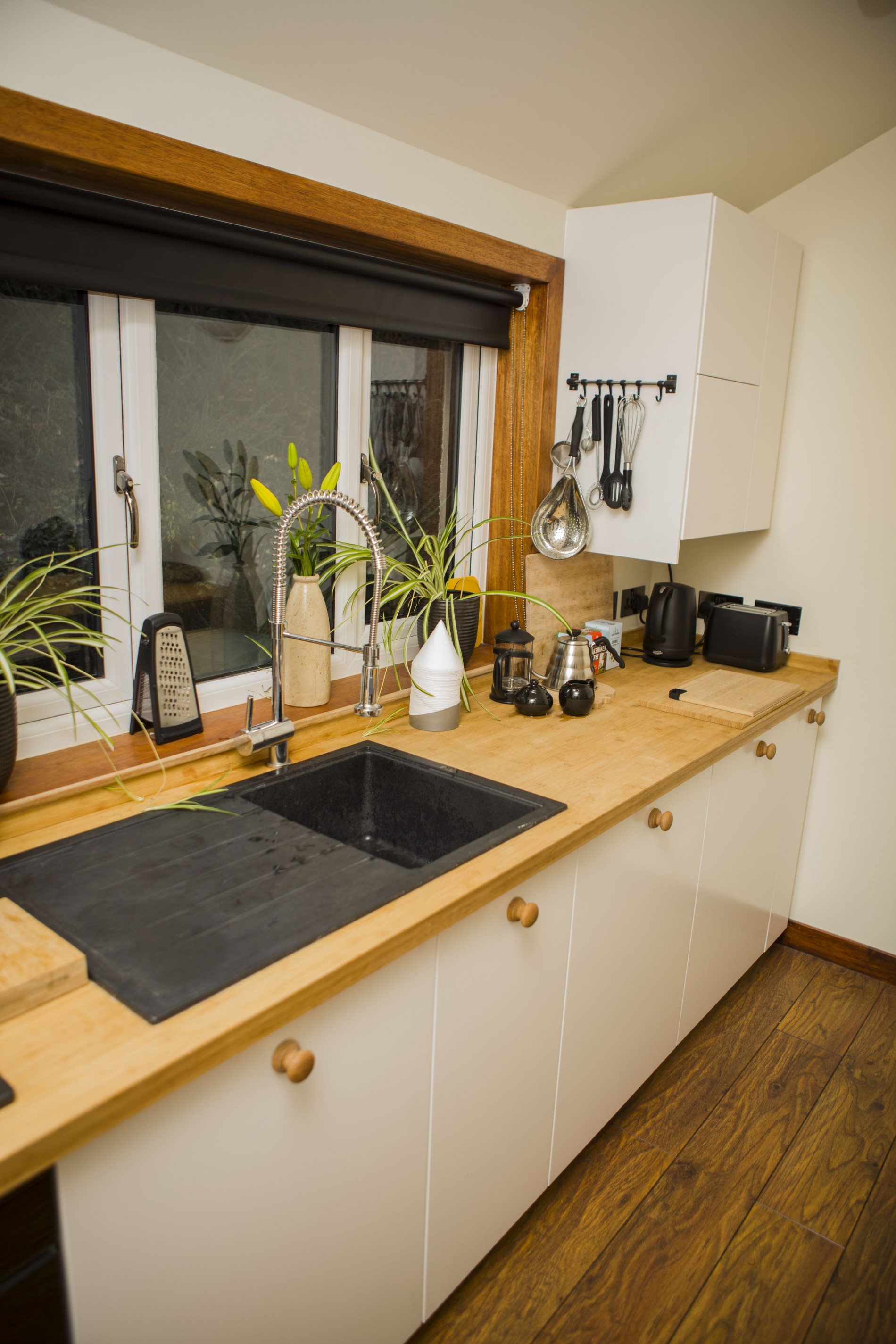 Kitchen counter with sink and various cooking utensils.