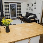 looking from the kitchen to the cosy sofa and stove by the glass garden door