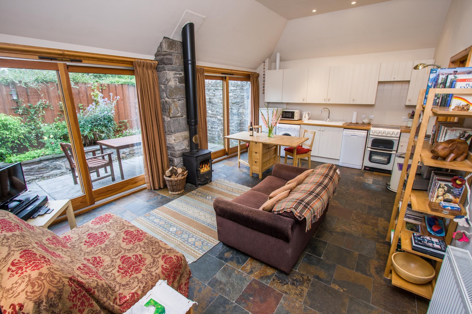 Open plan living room and dining area with wood burning stove. TV and DVD in living room