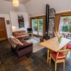 Open plan living room and dining area with wood burning stove. TV and DVD in living room