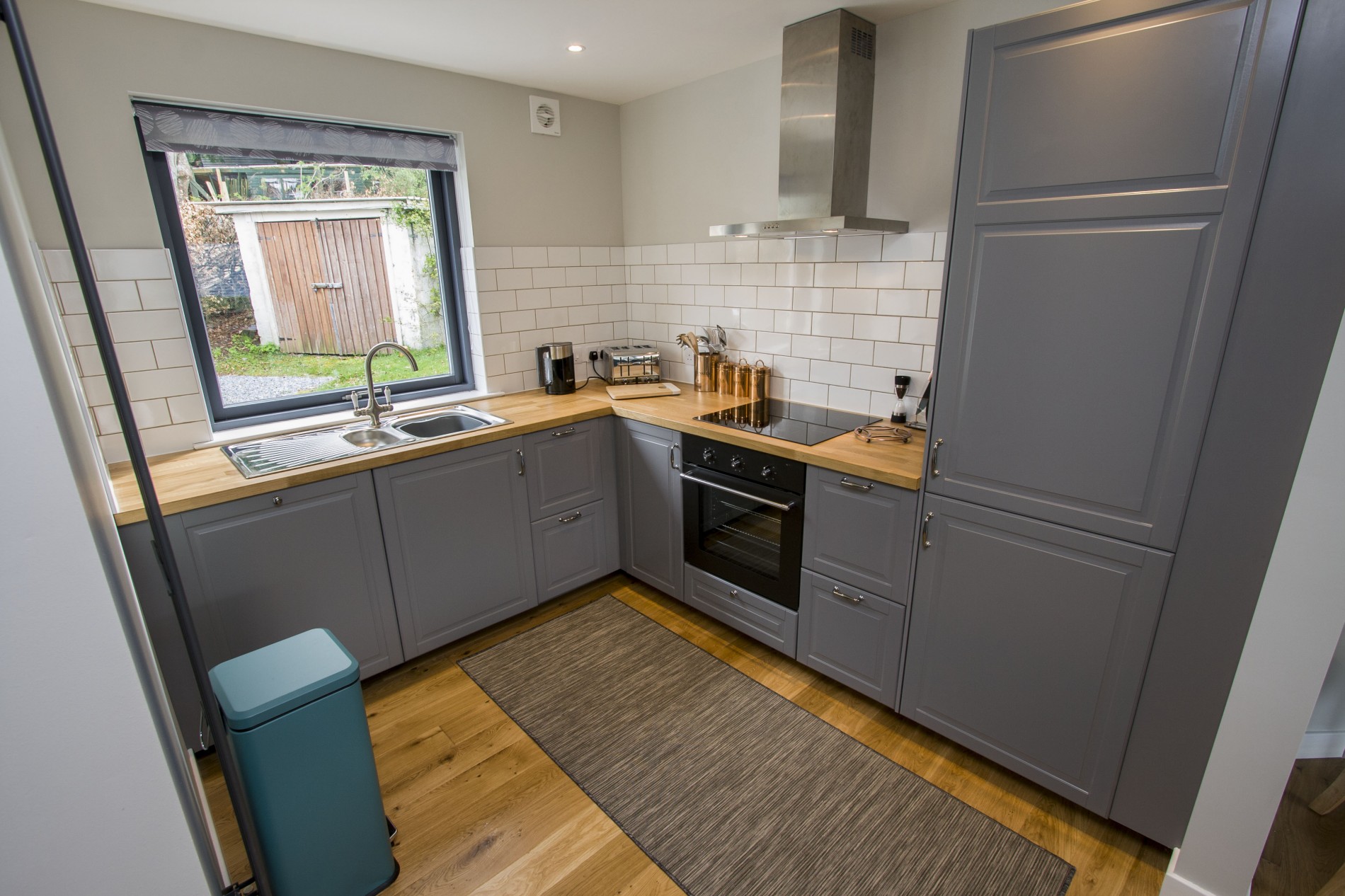 Kitchen featuring sink, electric hobs, oven, dishwasher and fridge  freezer with ample cupboard storage for food and drinks