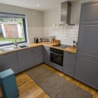 Kitchen featuring sink, electric hobs, oven, dishwasher and fridge  freezer with ample cupboard storage for food and drinks