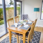 The dining table is situated next to the large Scandinavian windows and door which leads out to the decking area