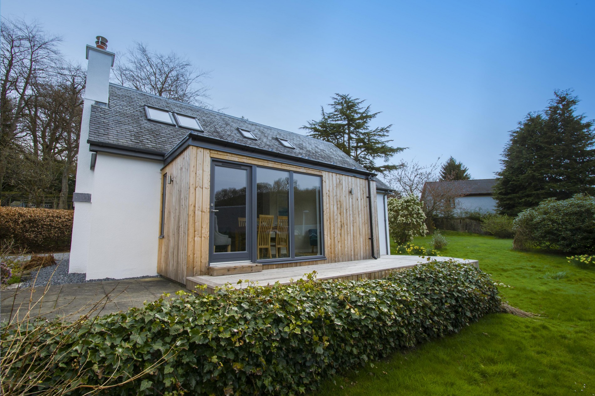 Outside Roneval features a spacious garden with decking area prefect for enjoying the sun and relaxing