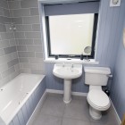 Family bathroom featuring WC, wash hand basin and bath with shower over