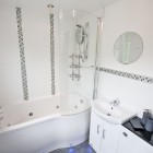 En-suite bathroom with WC, wash hand basin and jacuzzi bath with shower over.