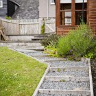 Steps beside the sloping lawn lead to the lower terrace of the garden where the games shed with dart board and table football can be found.
