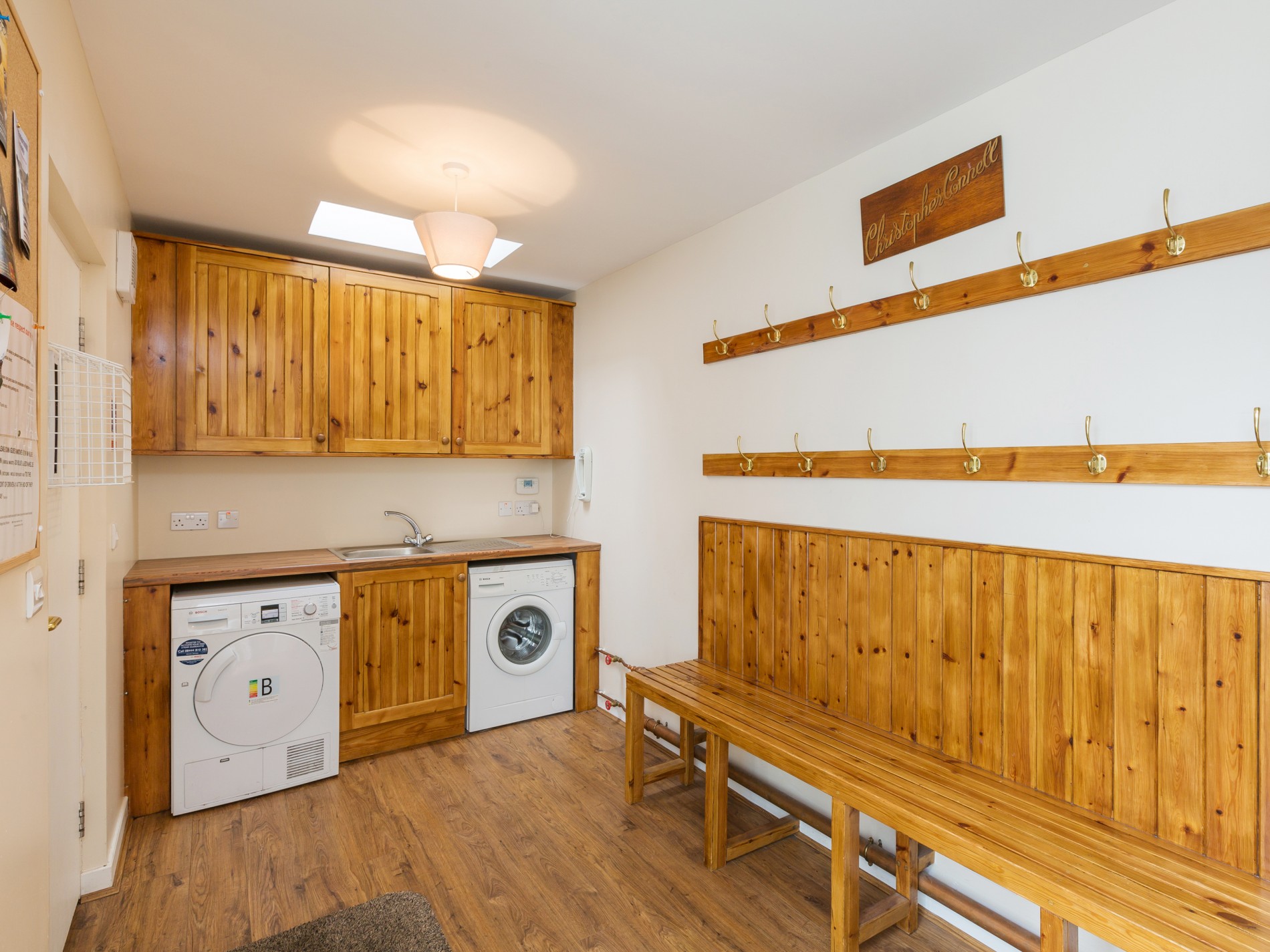 Washing room with pegs, benches, washing machine, sink and dryer