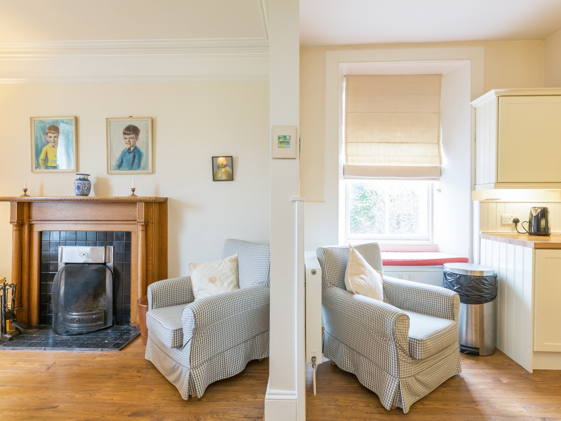 Two armchairs, one in dining room with fireplace other in kitchen