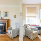 Two armchairs, one in dining room with fireplace other in kitchen