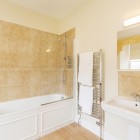 Bathroom with shower/ bath, towel radiator and sink